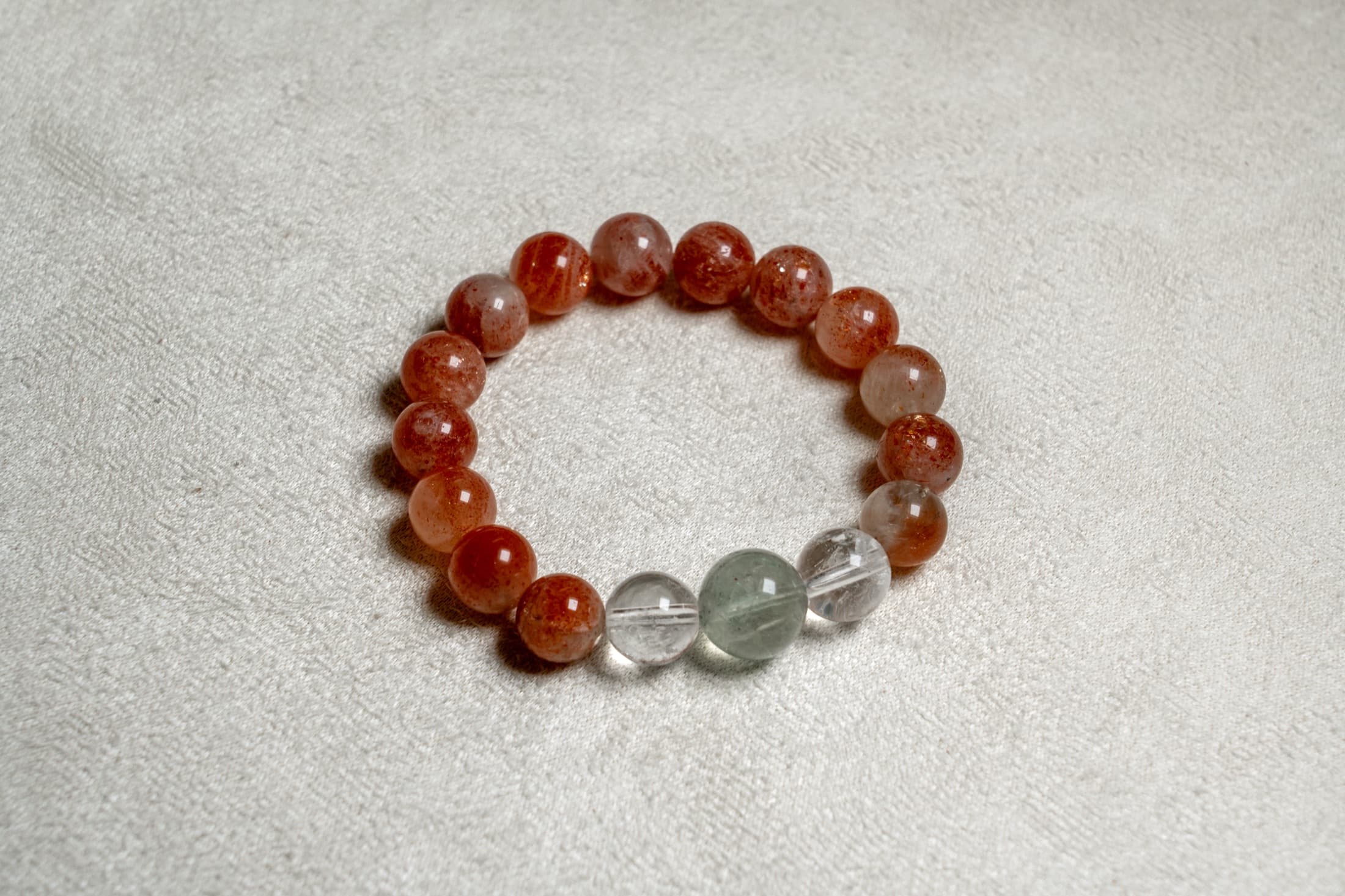 Warm-toned custom crystal bracelet arranged on linen